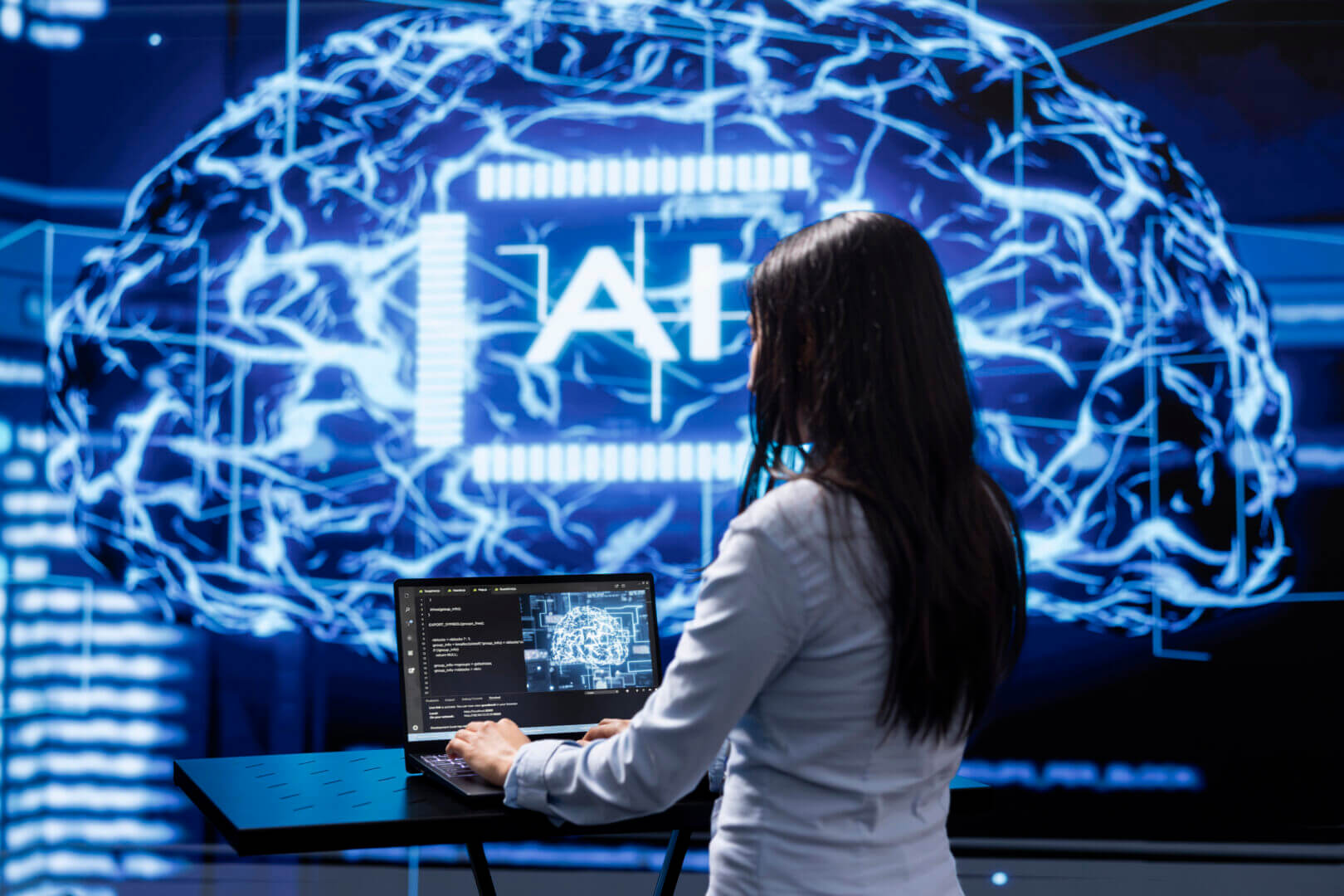Mujer utilizando software de machine learning en laptop para desarrollar autoencoders, una tecnología clave para la compresión y detección de anomalías en datos empresariales.
