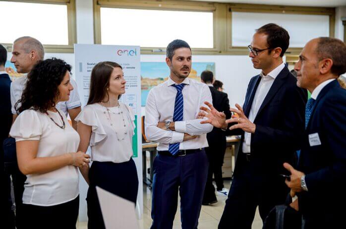Grupo de profesionales y directivos dialogando en un evento empresarial, ilustrando la importancia de la colaboración y el liderazgo en proyectos de Business Process Reengineering.