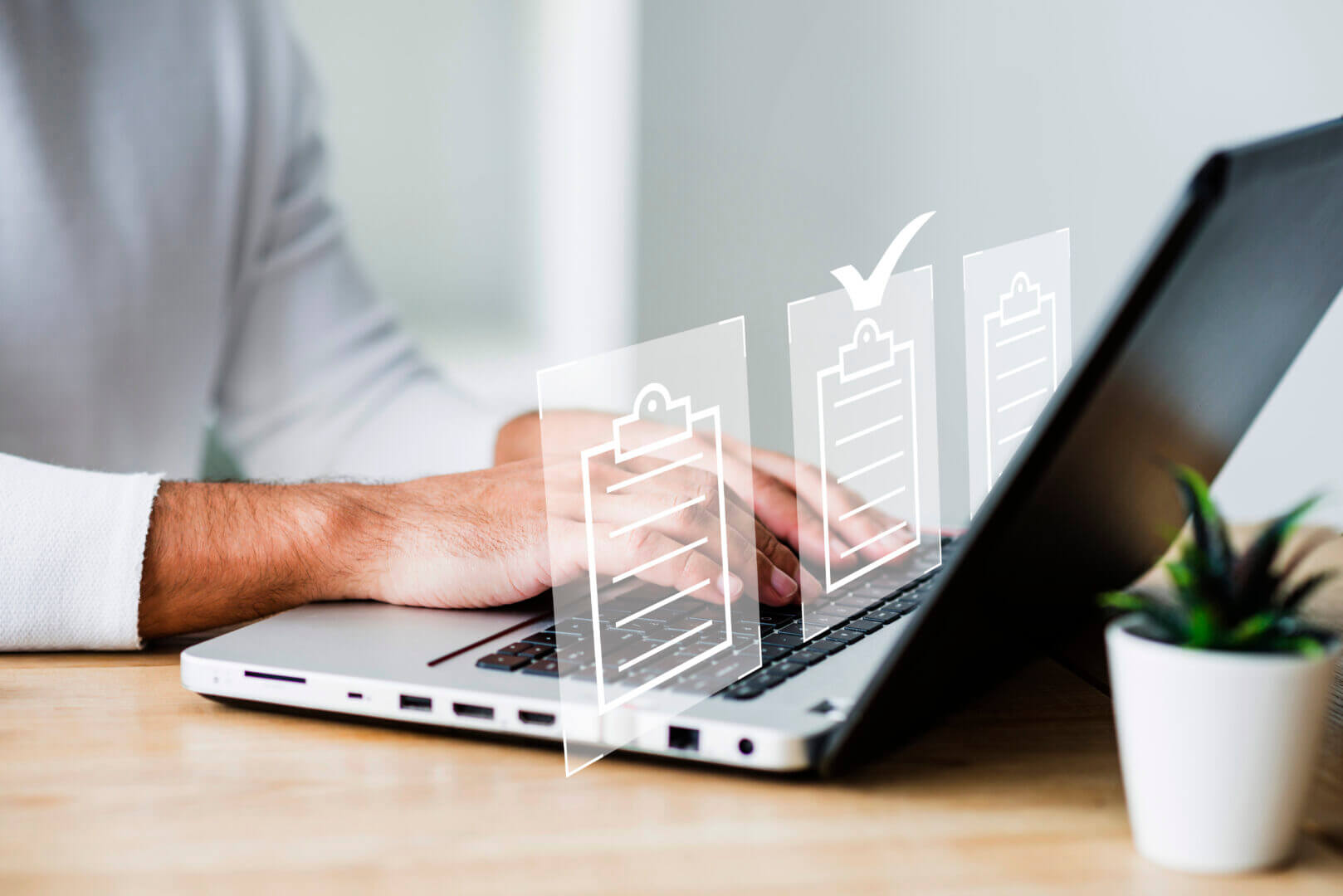 Persona trabajando en laptop con íconos de checklist, representando la validación automatizada de normativas mediante DNN en entornos corporativos.