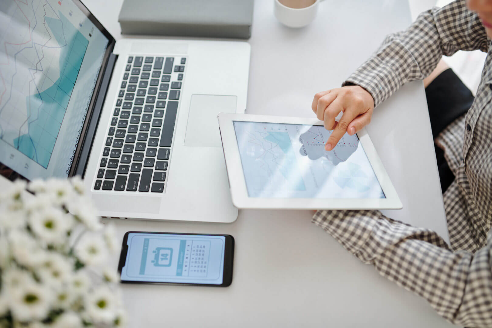 Persona trabajando con gráficos en una tablet conectada a laptop, en un entorno colaborativo que ilustra el uso empresarial de una nube comunitaria.
