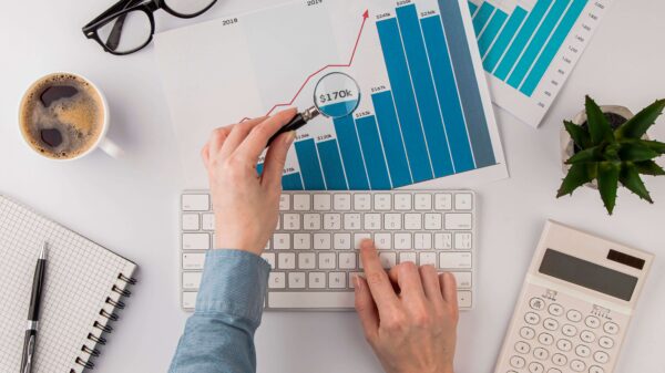 Manos de un profesional que analiza gráficos de inversión y costos en la oficina, en un contexto de mayor Presión del CFO sobre el gasto en tecnología.