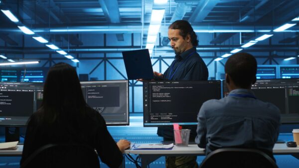 Equipo de analistas en un SOC usa monitores con código y un portátil, ejemplo de Outsourcing de ciberseguridad para proteger infraestructuras empresariales.