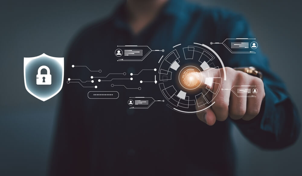 Persona interactuando con una interfaz digital de seguridad que muestra un escudo, un flujo de autenticación y una huella dactilar, ilustrando cómo el Software NDR protege redes empresariales.