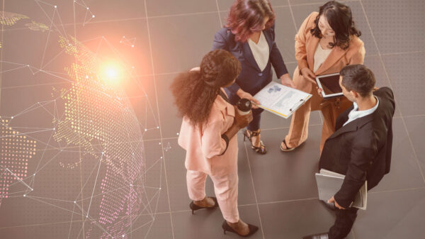 Grupo de profesionales analizando informes en un entorno corporativo con un mapa digital global, en un contexto de tendencias tecnologías para 2026.