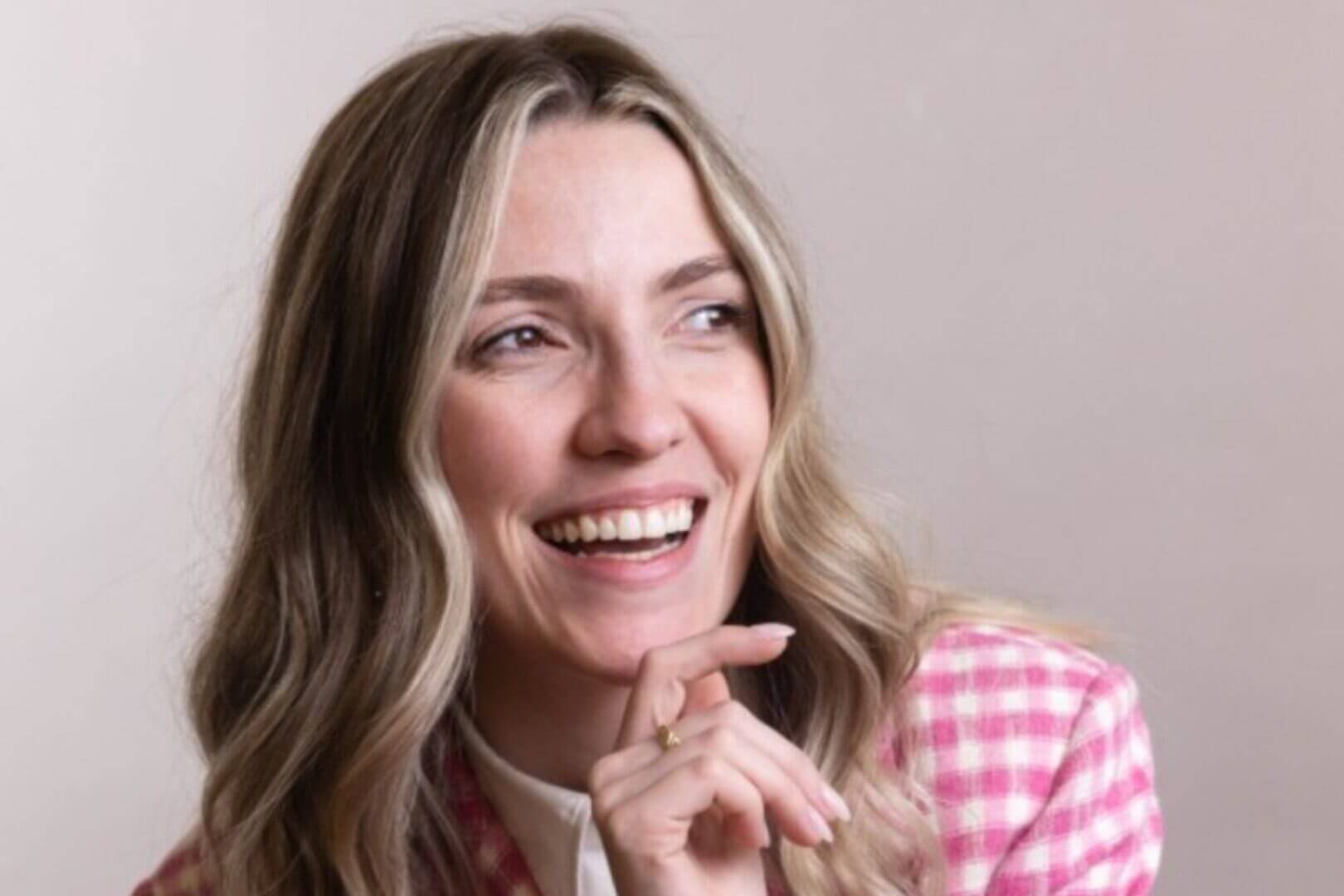 Jennifer Roca, cofundadora de MUCHO Brand y COO de Inside Studios, sonríe con la mano cerca del rostro y representa creatividad y criterio en IA sin manual.