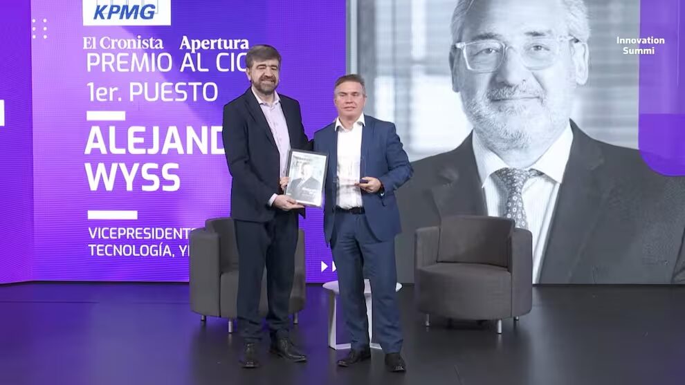 Leonardo Iglesias, CISO de YPF, recibe en nombre de Alejandro Wyss el premio CIO del Año 2025 en el Innovation Summit, en escenario con pantalla institucional de fondo.