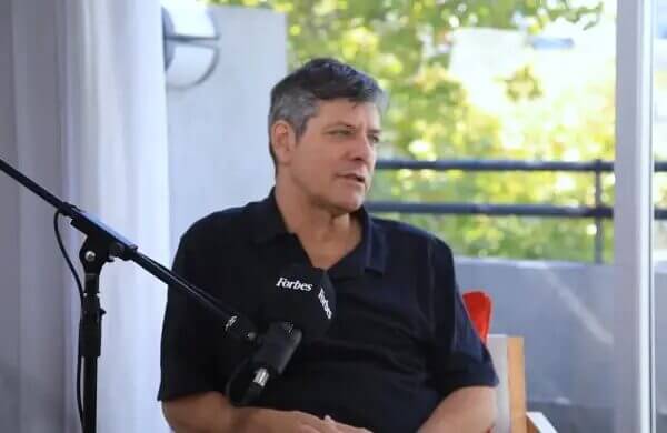 Hombre con camisa oscura, sentado frente a un micrófono de Forbes en una entrevista sobre Pergolini e inteligencia artificial.