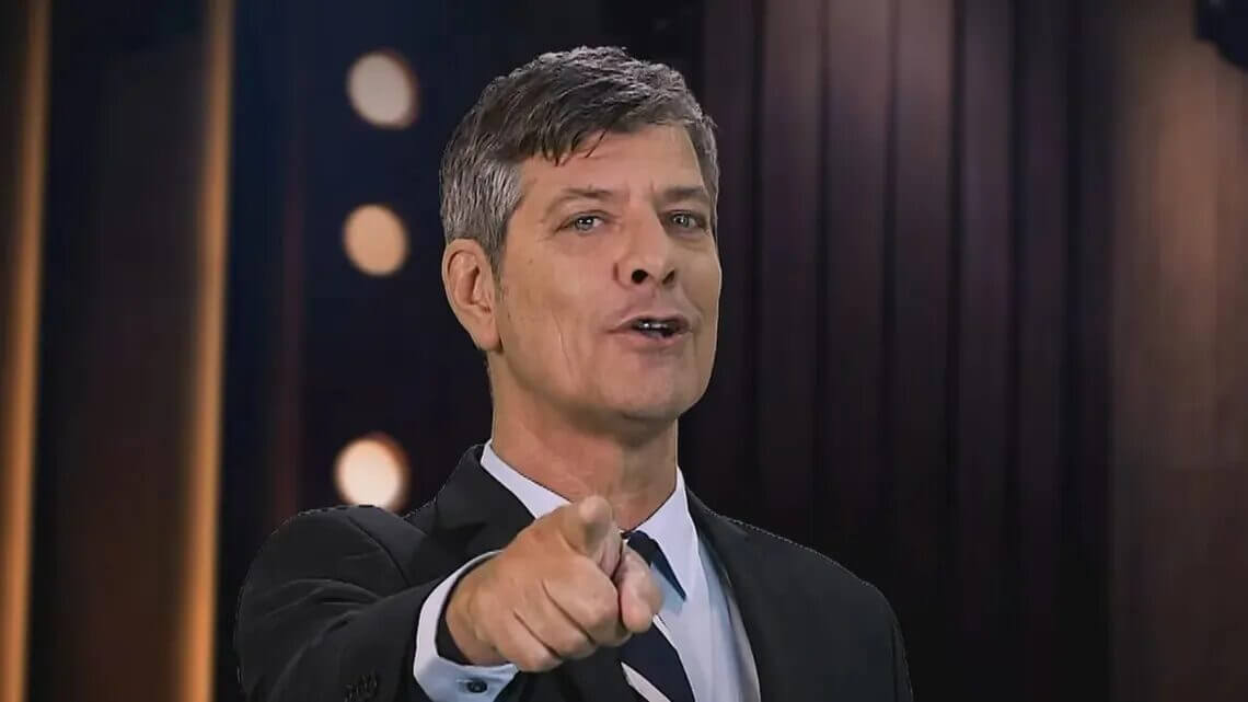 Hombre de traje señala a cámara en un estudio con fondo oscuro, en una imagen para una nota sobre Pergolini e inteligencia artificial.