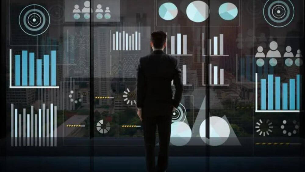 Ejecutivo observa dashboards con gráficos e indicadores, una imagen que representa el uso de analítica de red para tomar decisiones en telecomunicaciones.