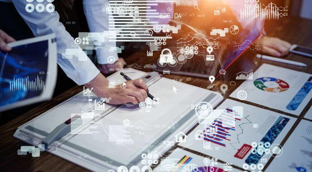 Equipo de negocio analiza reportes y gráficos digitales, ilustrando cómo la arquitectura de datos permite convertir información dispersa en decisiones confiables.