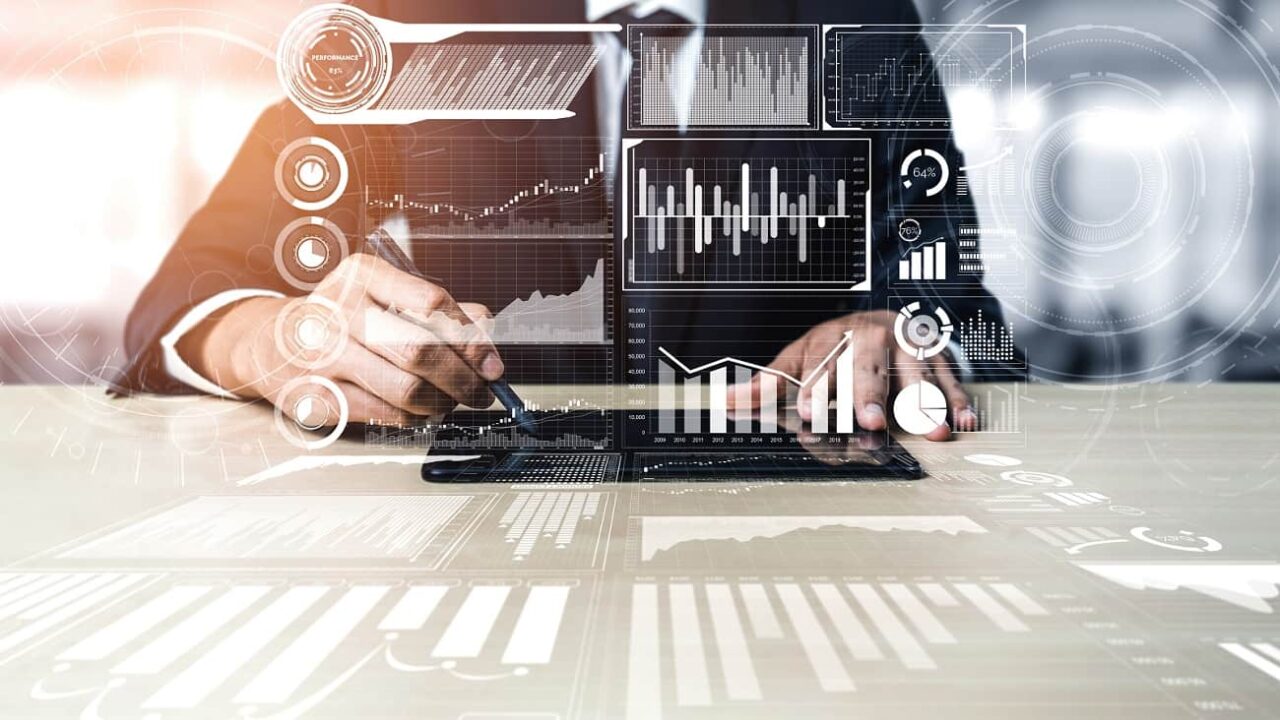 Ejecutivo trabaja frente a dashboards digitales, una imagen que representa el rol del Data Architect en la arquitectura de datos empresarial.