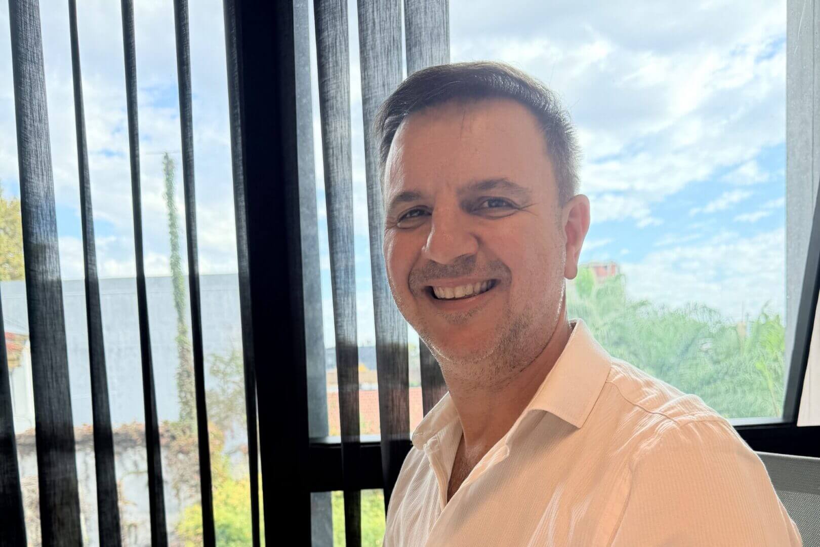 Retrato de un ejecutivo de QuadMinds en una oficina, junto a una ventana; imagen para una nota sobre software logistico y visibilidad operativa.