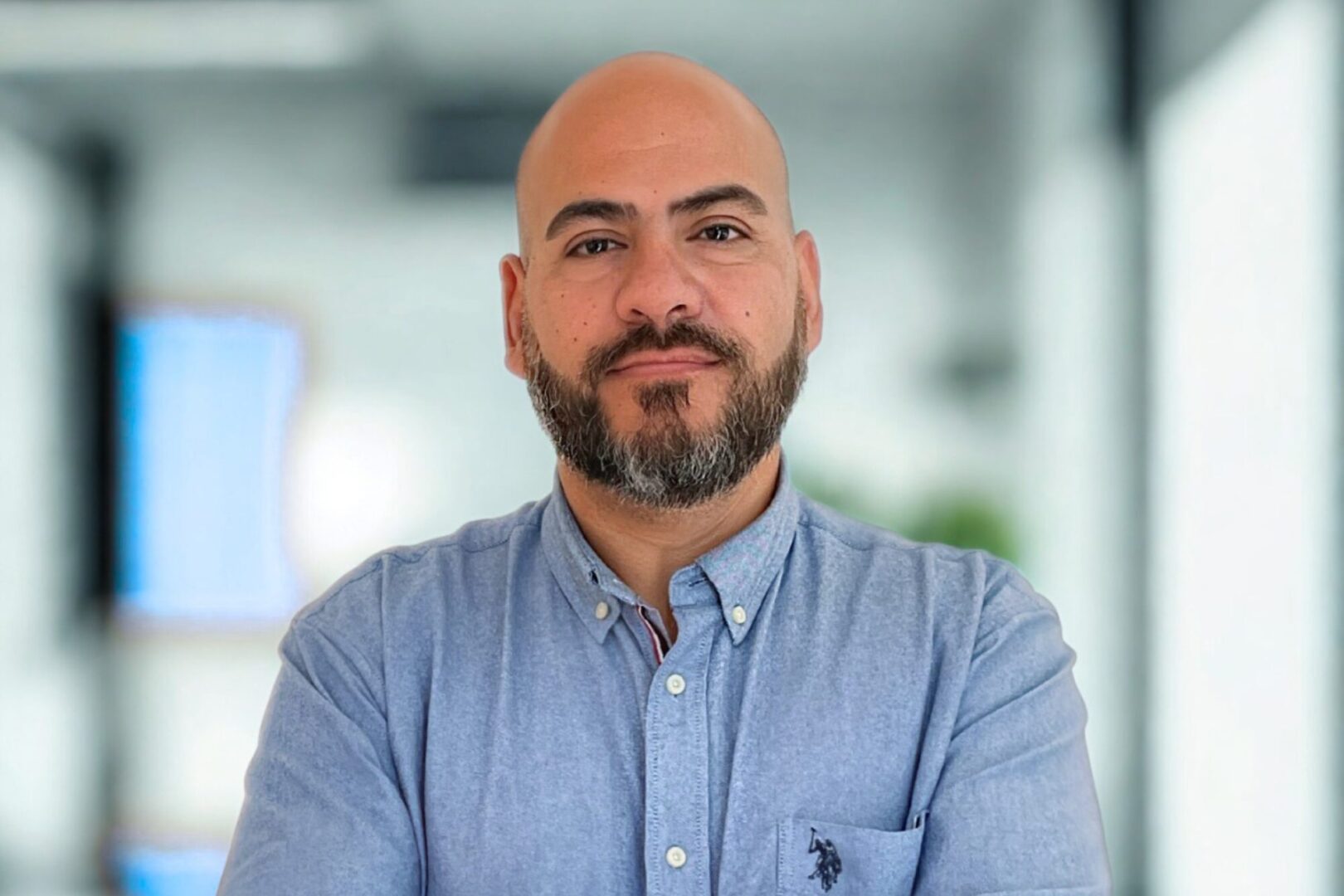 Retrato de ejecutivo con camisa azul en oficina para nota sobre ciberseguridad en consumo masivo.