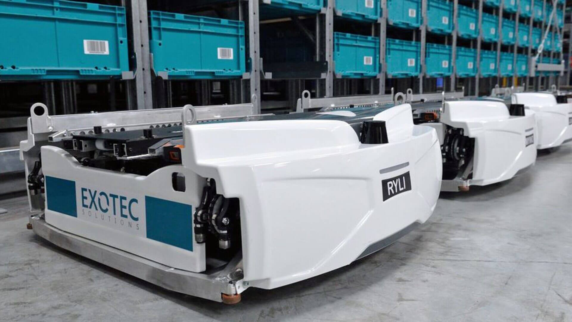 Robots Exotec operan junto a estanterías con contenedores en un sistema de picking automatizado para almacenes de retail.