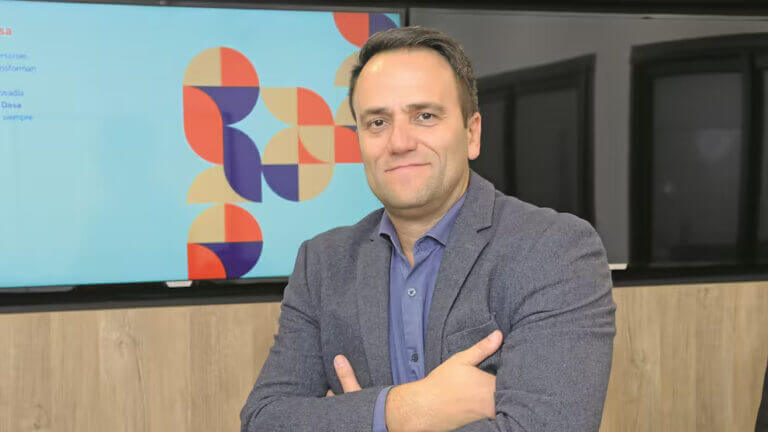 Retrato de Pablo Jaca, CIO y CTO de DASA Argentina, en oficina corporativa con pantalla institucional de fondo.