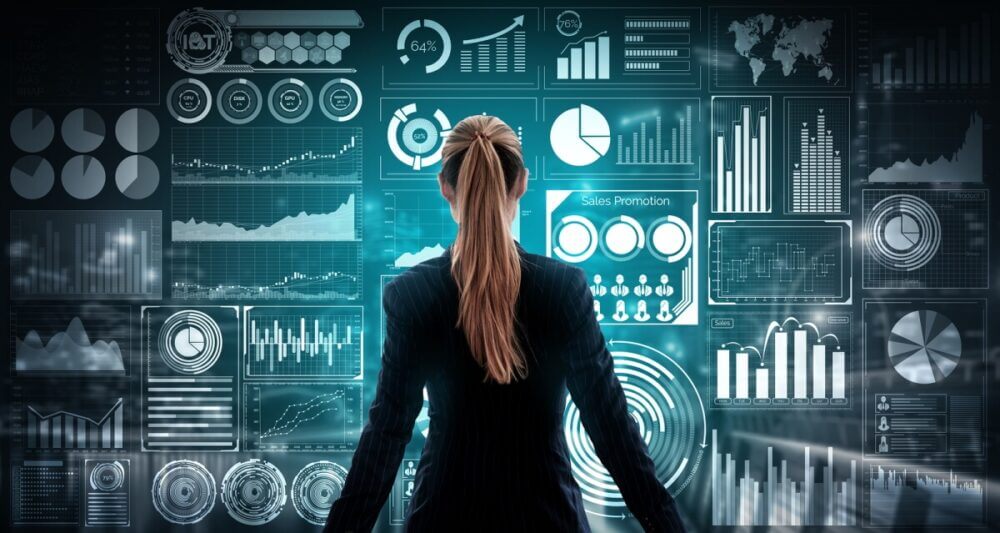Profesional observa múltiples dashboards empresariales con gráficos e indicadores, ilustrando cómo la capa semántica ayuda a BI, IA y negocio a usar definiciones compartidas.