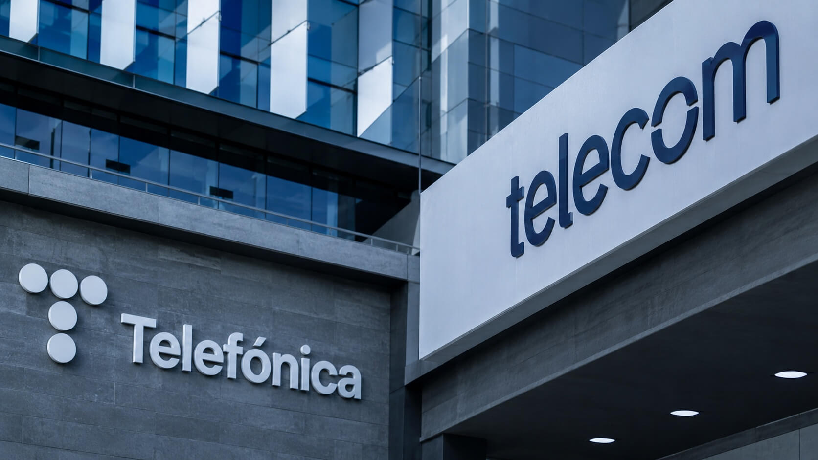Fachada de edificio corporativo con los logos de Telecom y Telefónica, en una imagen ilustrativa sobre la compra de Telefónica por parte de Telecom.