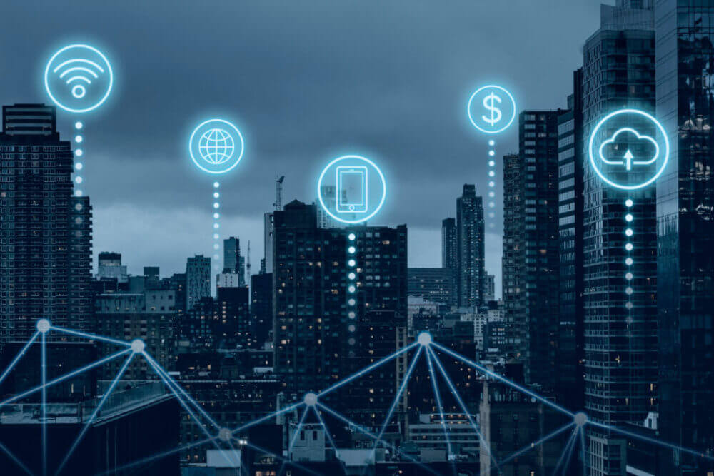 Ciudad conectada con iconos digitales de conectividad, nube y dispositivos, ilustrando cómo los datos de red 5G ayudan a las telcos a optimizar servicios.