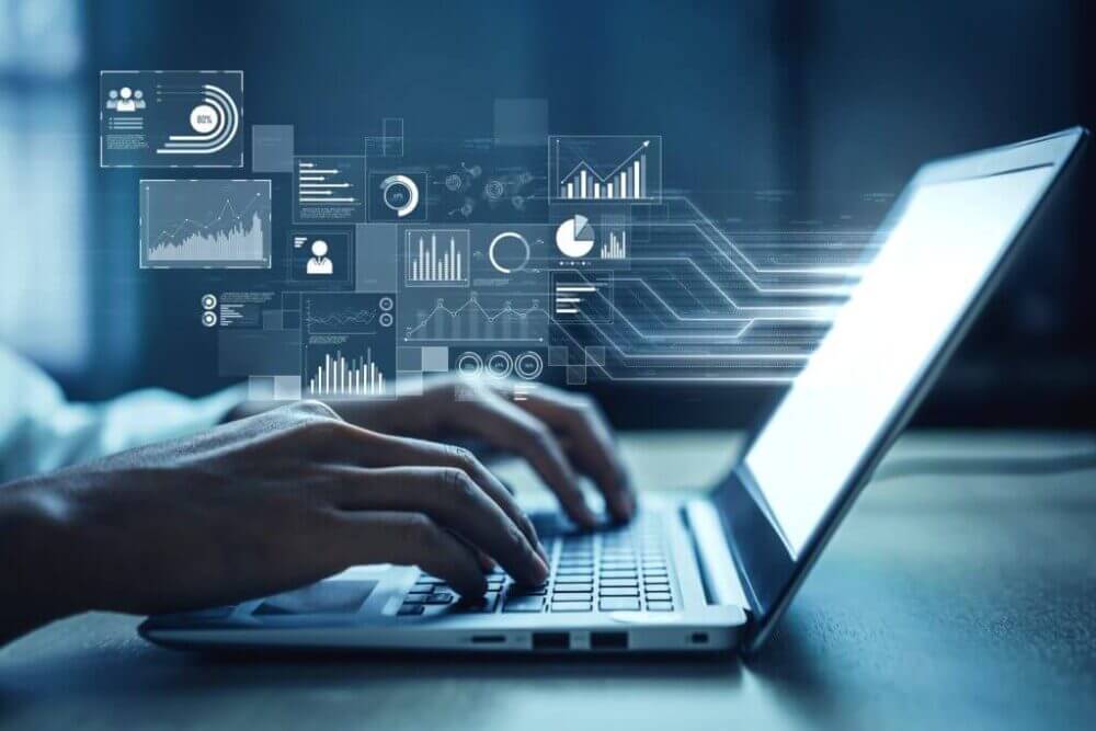 Persona trabaja en una laptop con gráficos de analytics proyectados, representando el uso de capa semántica para consultar datos y mejorar decisiones de negocio.