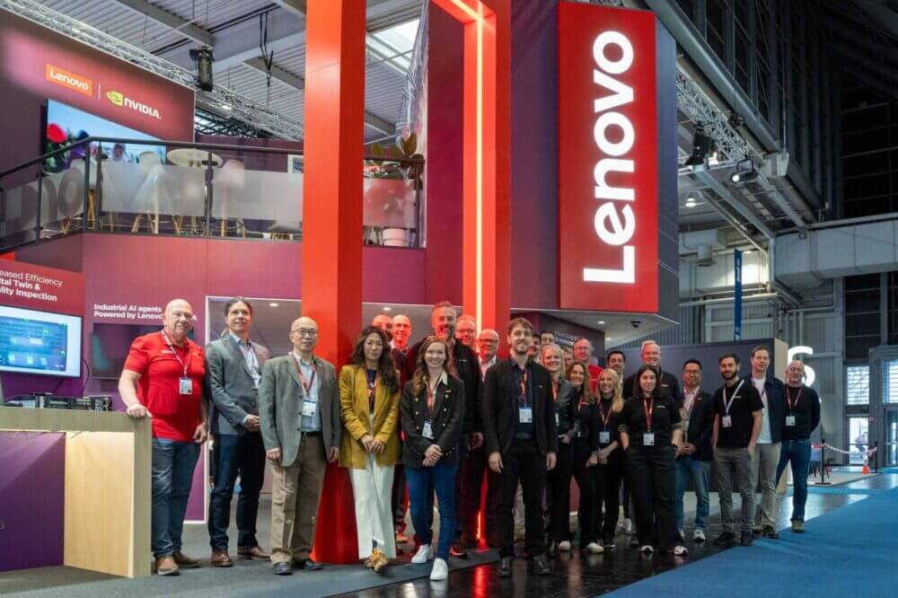 Equipo de Lenovo posa en su stand de Hannover Messe, con señalización de Lenovo y NVIDIA, en una nota sobre IA industrial aplicada a manufactura.