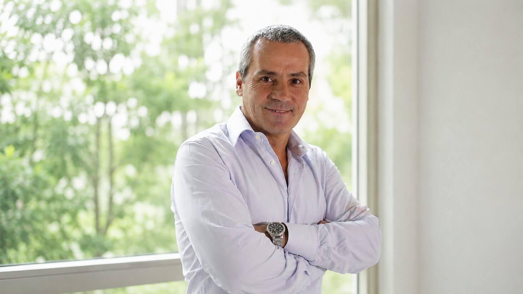 Texto alt Eduardo del Piano posa con camisa clara y brazos cruzados frente a una ventana, en un retrato profesional para una nota sobre tecnología, salud y energía.