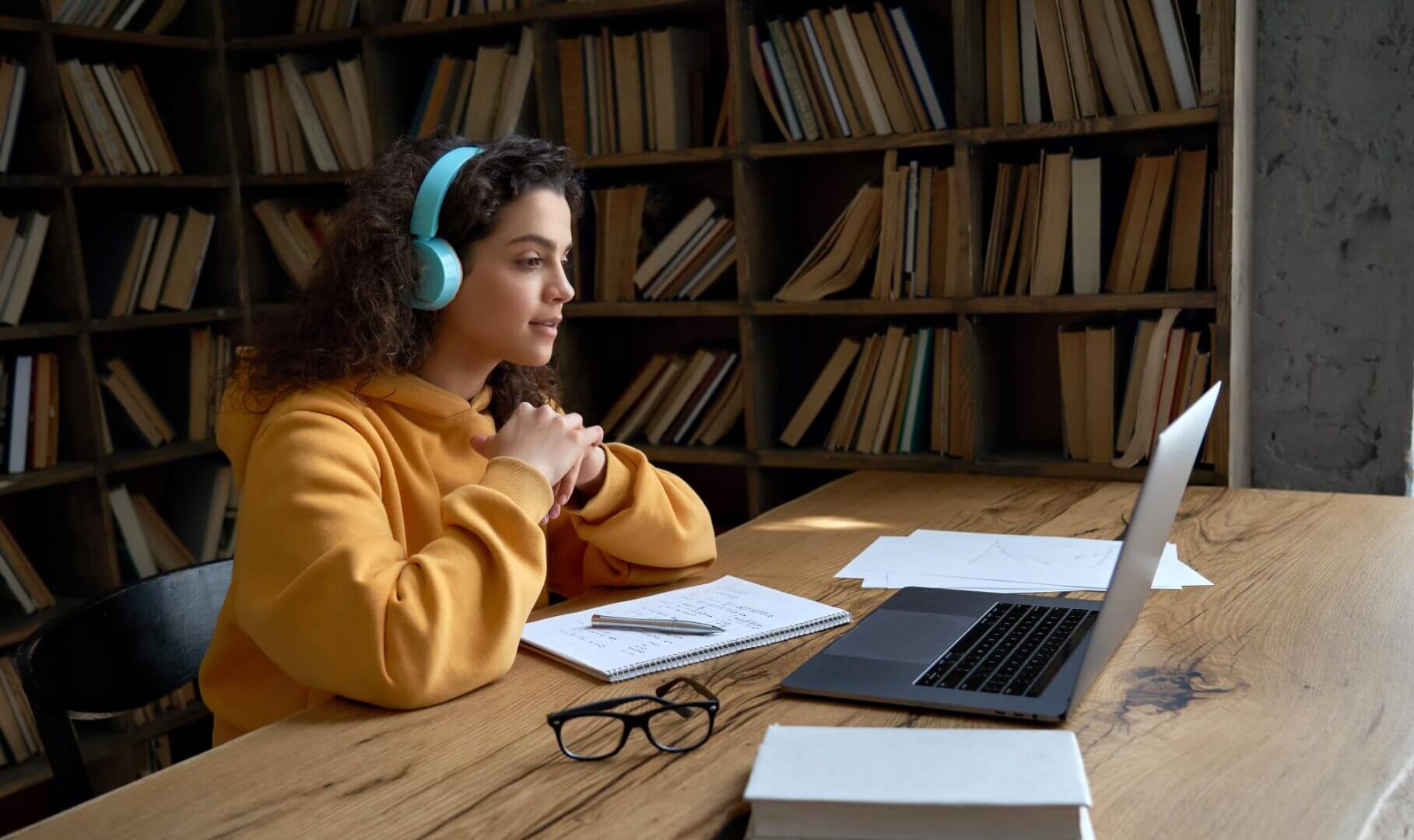 Estudiante con auriculares participa en una clase online con laptop, ejemplo de cómo el learning analytics analiza interacciones digitales de aprendizaje.