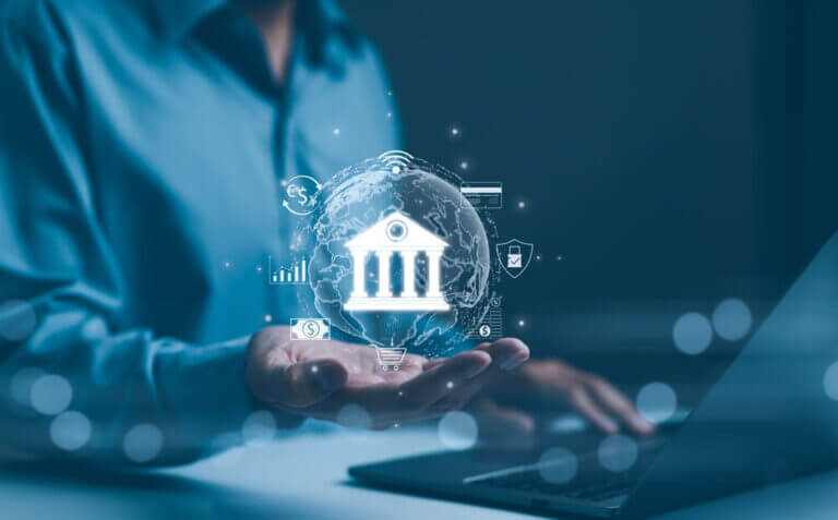 Persona sostiene una representación digital de un banco con íconos financieros, imagen asociada a AI-ready data en banca y modelos de IA para decisiones financieras.