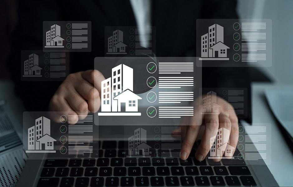 Persona usa una laptop con paneles digitales de propiedades, representando portfolio analytics en real estate para comparar activos inmobiliarios.