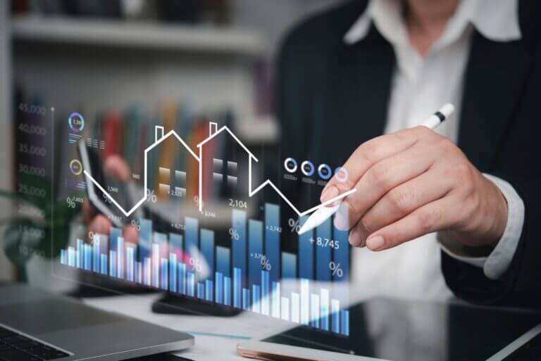 Profesional revisa gráficos digitales de propiedades y rendimiento, ilustrando el uso de portfolio analytics en real estate para decisiones de negocio.