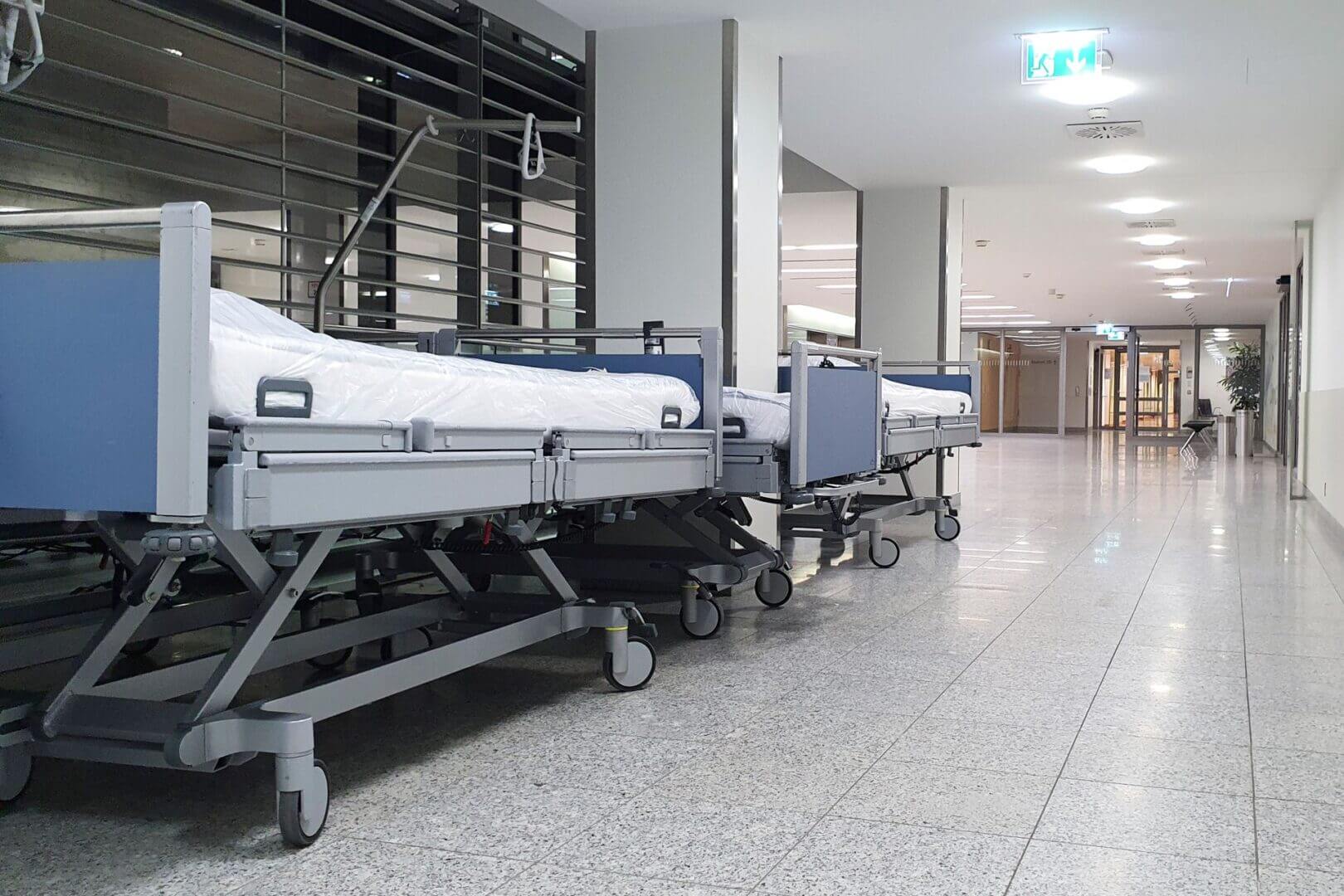 Sala hospitalaria con camas, equipos médicos y monitores junto a las paredes, preparada para internación y atención clínica.