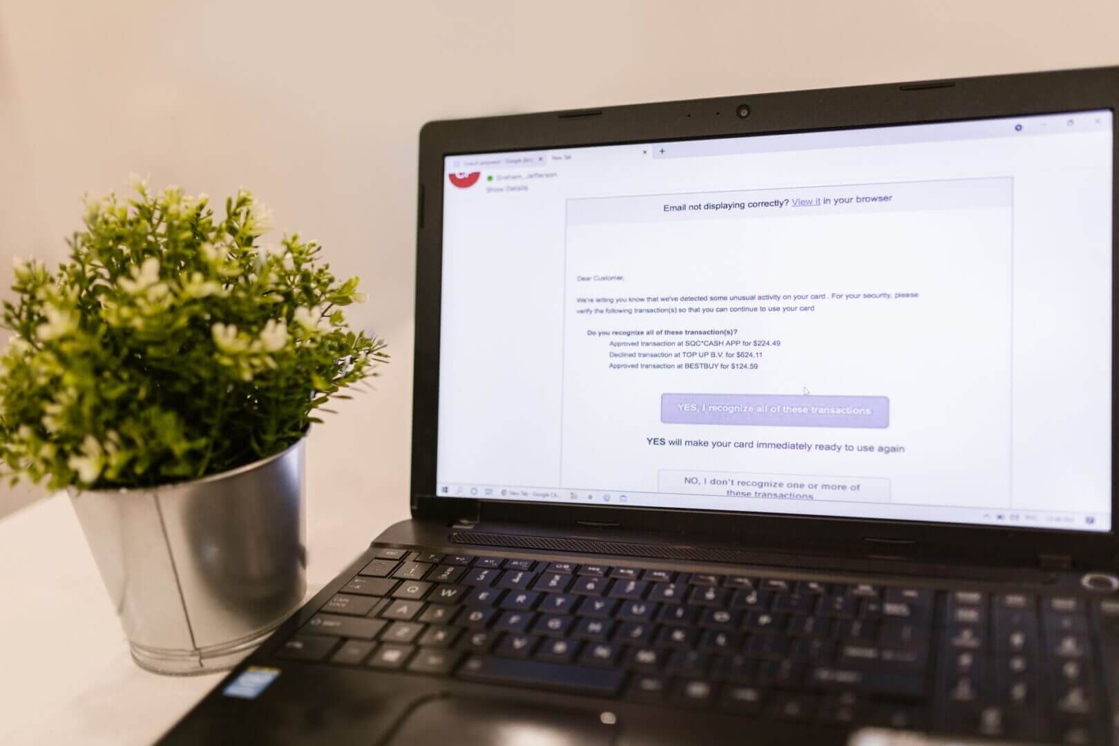 Laptop mostrando un supuesto correo bancario que solicita verificar transacciones sospechosas, posible ejemplo de phishing financiero.