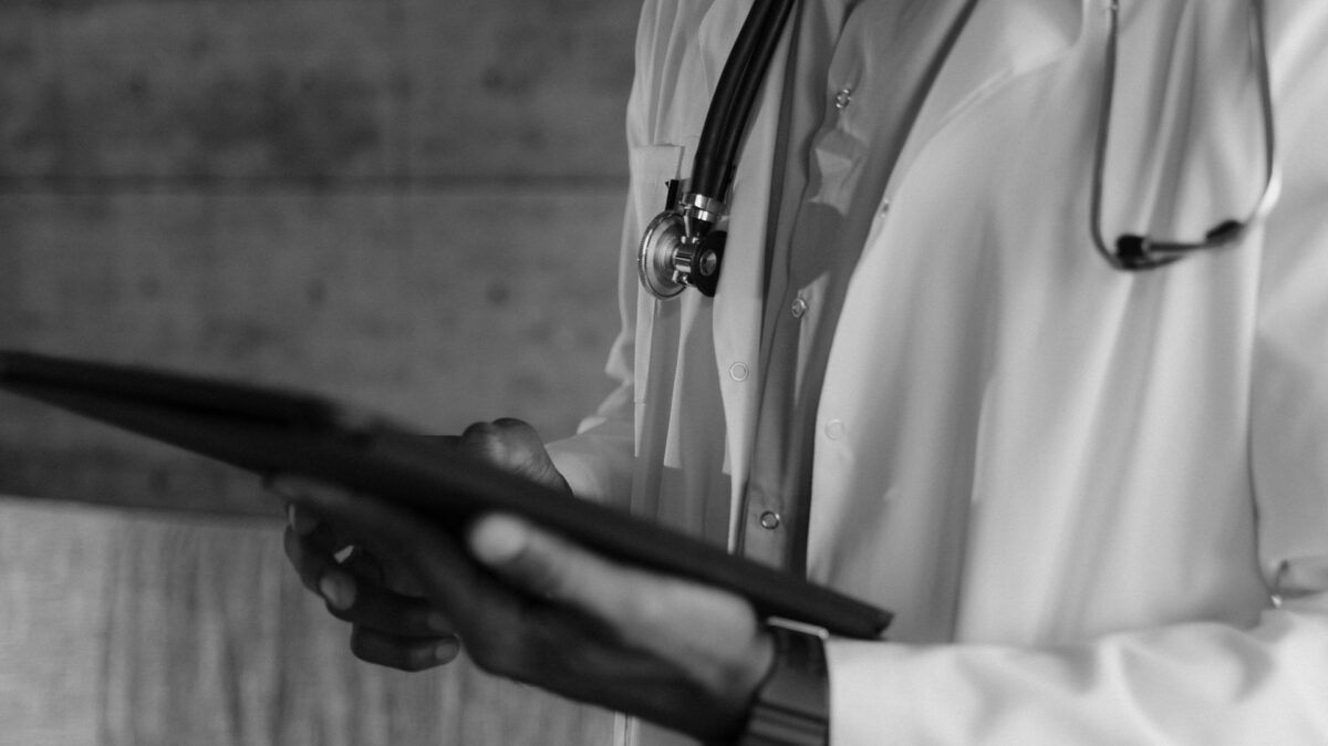 Profesional de la salud consulta información médica digital en una tablet, en el marco de la transformación tecnológica del sector sanitario.