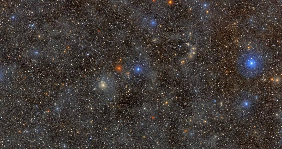 Campo de estrellas y galaxias asociado al Observatorio Vera Rubin, con puntos de luz azules, naranjas y blancos sobre el cielo oscuro.