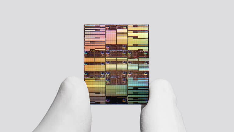 Microchip rectangular sujeto entre dos dedos, imagen asociada a chips de IA y semiconductores avanzados.