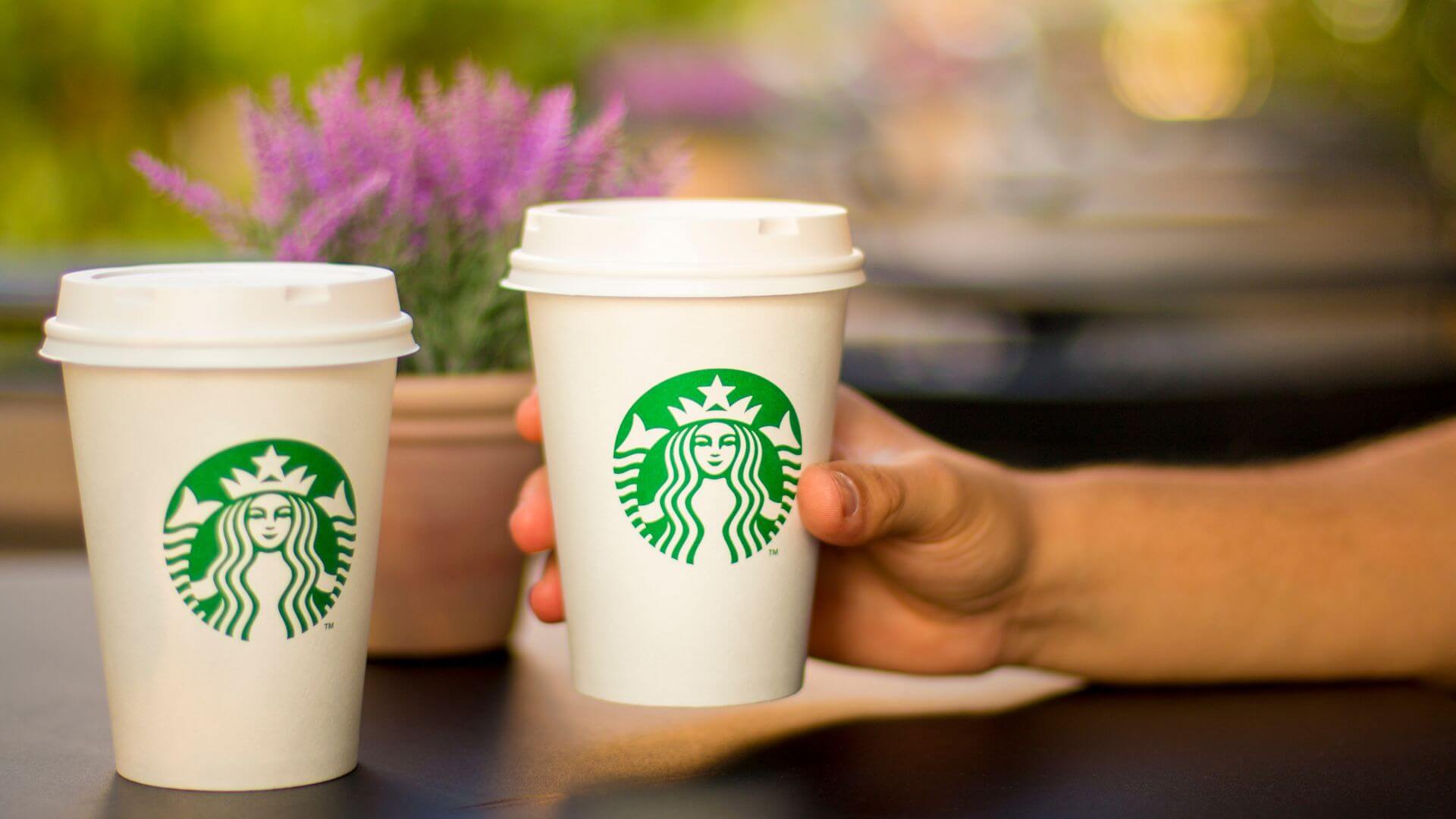 Dos vasos de café con el logotipo de Starbucks sobre el mostrador de uno de sus locales.