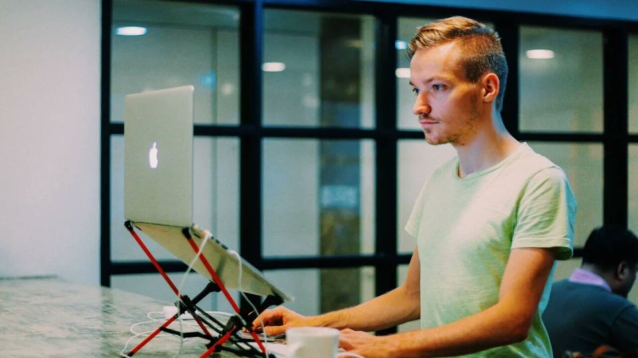 Emprendedor trabaja frente a una notebook en una oficina, en una nota sobre Pieter Levels y la creación de videojuegos con IA.