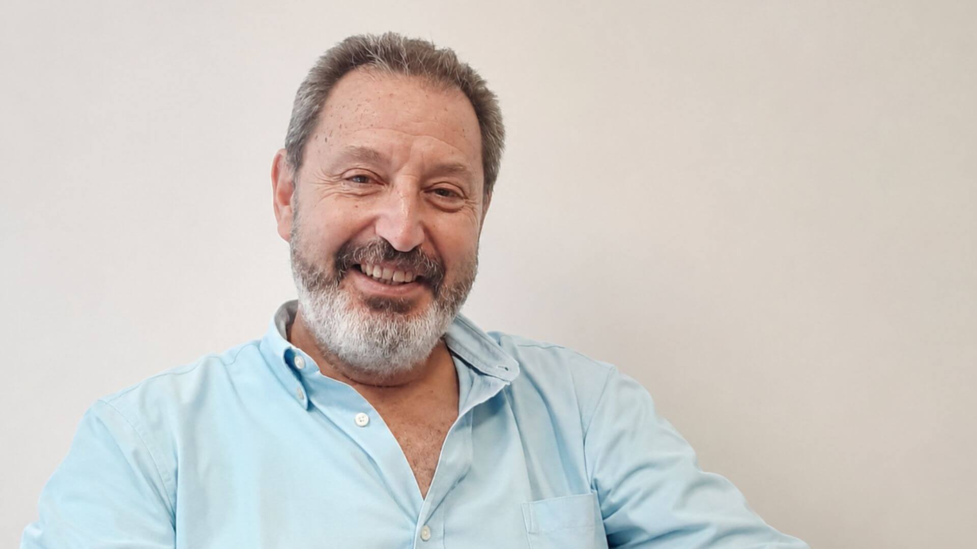 Rafael Ibáñez, CEO de SkyOnline y especialista en cloud híbrida en salud y farma, posa con una camisa celeste ante un fondo claro.