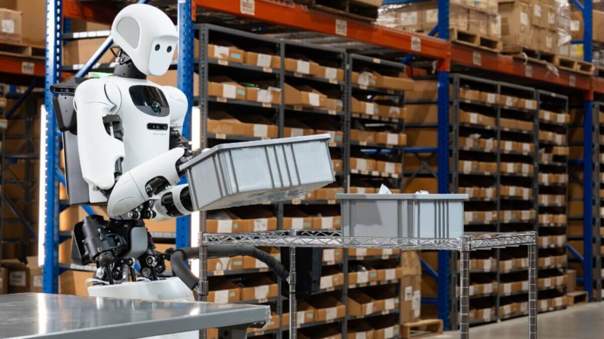 Robot humanoide de Robot Park manipula bandejas en un depósito con estanterías llenas de cajas.