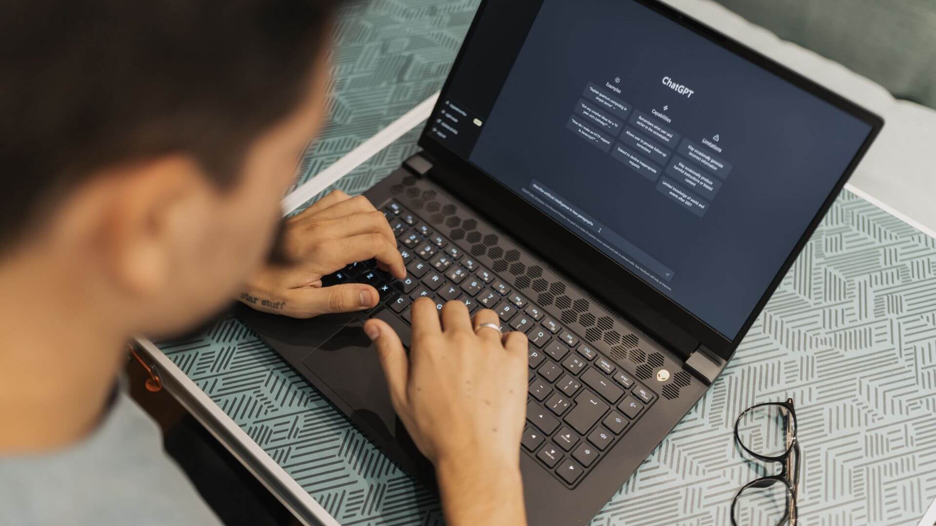 Persona consulta ChatGPT desde una notebook, una escena asociada al costo oculto de la IA en el trabajo cotidiano.
