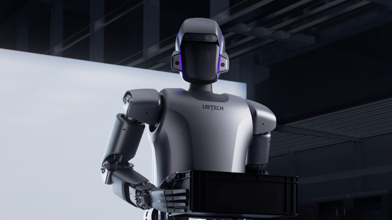 Robot de UBTech con una caja negra en una planta industrial, ejemplo del uso de robots humanoides en tareas logísticas.