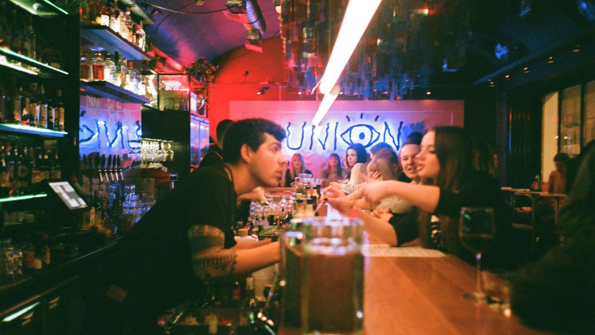 Jóvenes conversan en un bar durante un encuentro organizado por 222, la app de citas que propone reuniones presenciales.