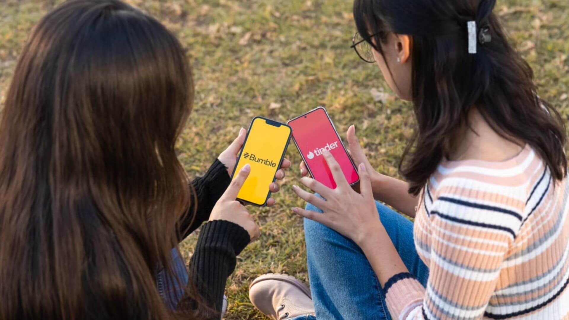 Dos jóvenes sostienen celulares con Tinder y Bumble, referentes tradicionales del mercado de app de citas.