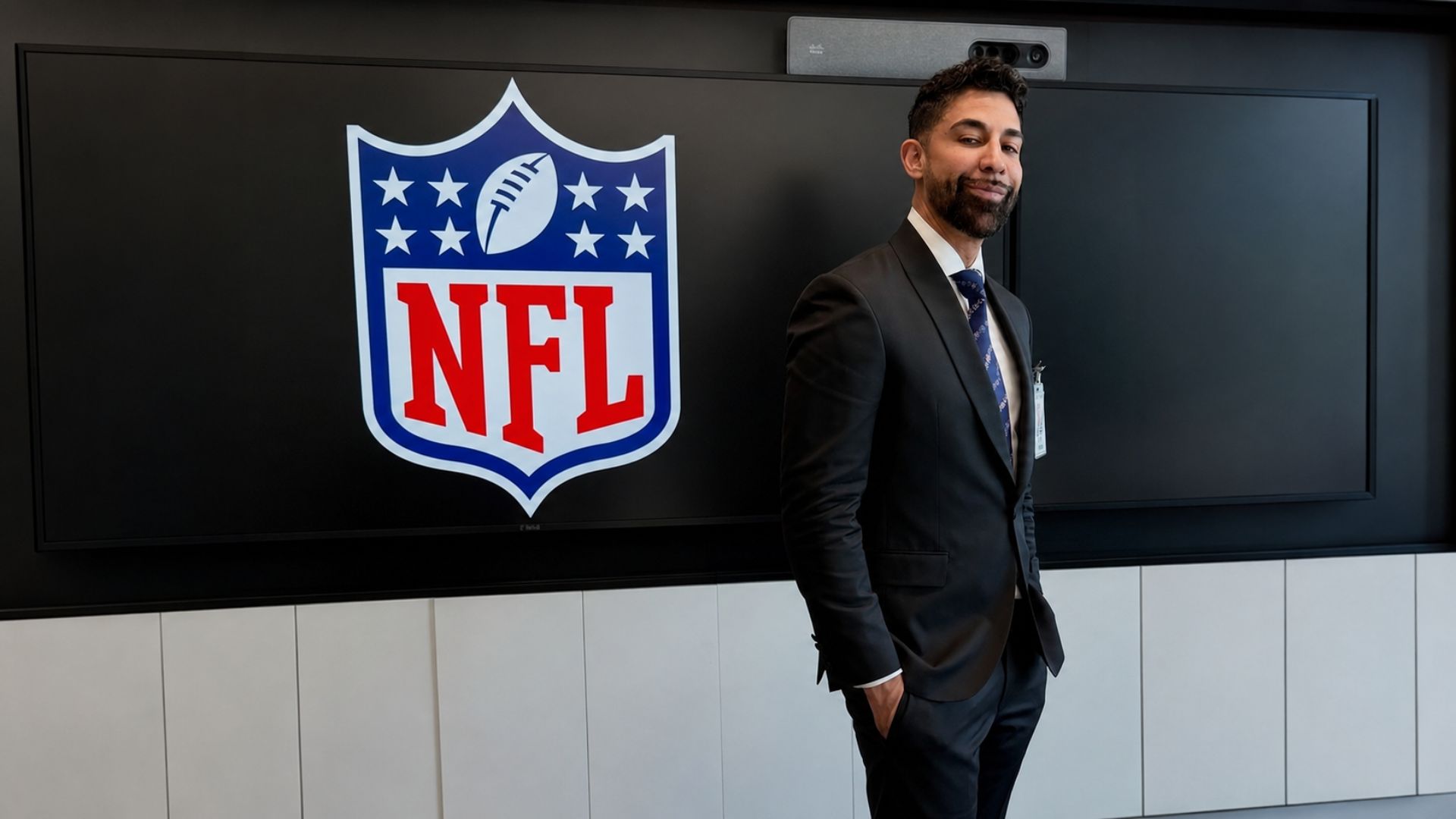 Hombre de traje junto al logotipo de la NFL, en una imagen vinculada con Dhar Mann y su negocio de contenidos digitales.