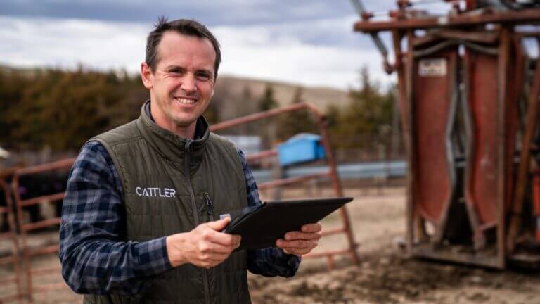 Integrante de Cattler utiliza una tablet dentro de un establecimiento dedicado a la producción ganadera.