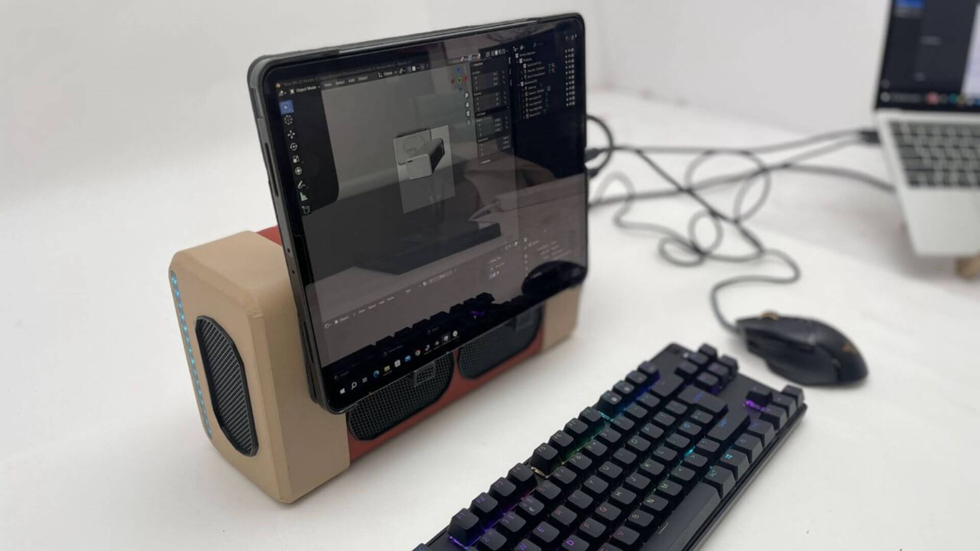 Dispositivo eGPU conectado a una pantalla, teclado y mouse en una estación de trabajo para tareas de diseño.