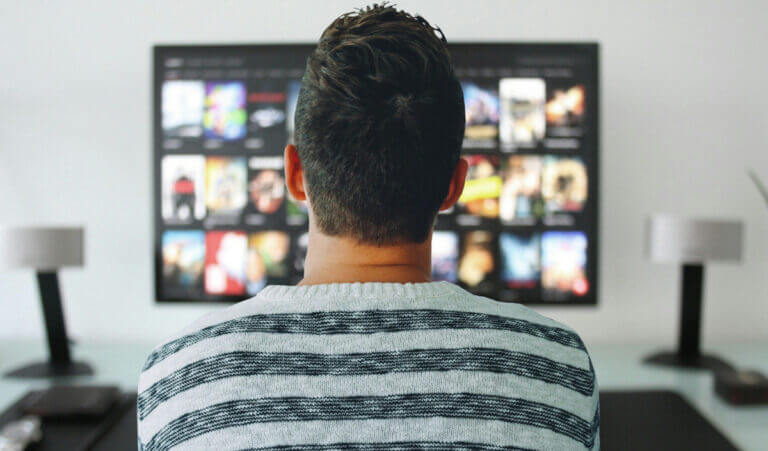 uario observa el catálogo de una plataforma de streaming en un televisor, una interacción cuyos datos pueden anticipar bajas de suscriptores.