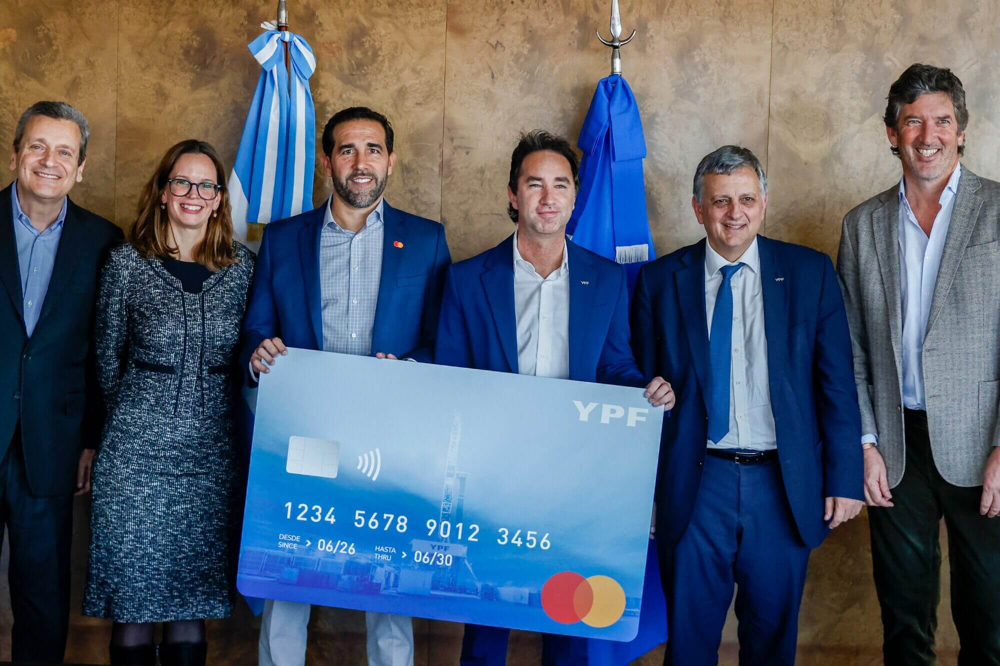 Directivos de YPF y Mastercard posan junto a una tarjeta gigante durante el anuncio de la Tarjeta prepaga YPF - Mastercard.