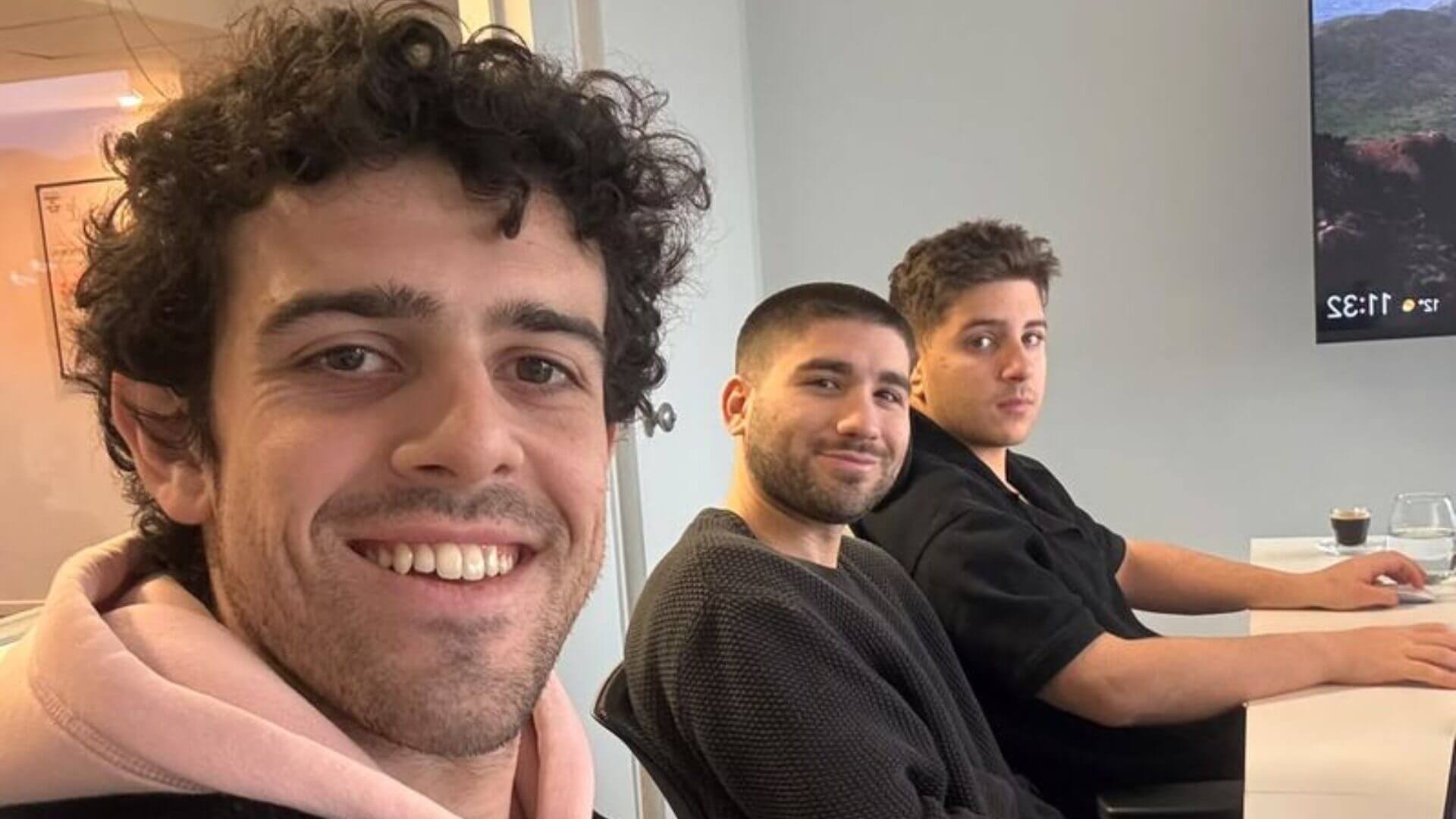 Tres integrantes del equipo de Talentum posan en una oficina frente a sus puestos de trabajo.