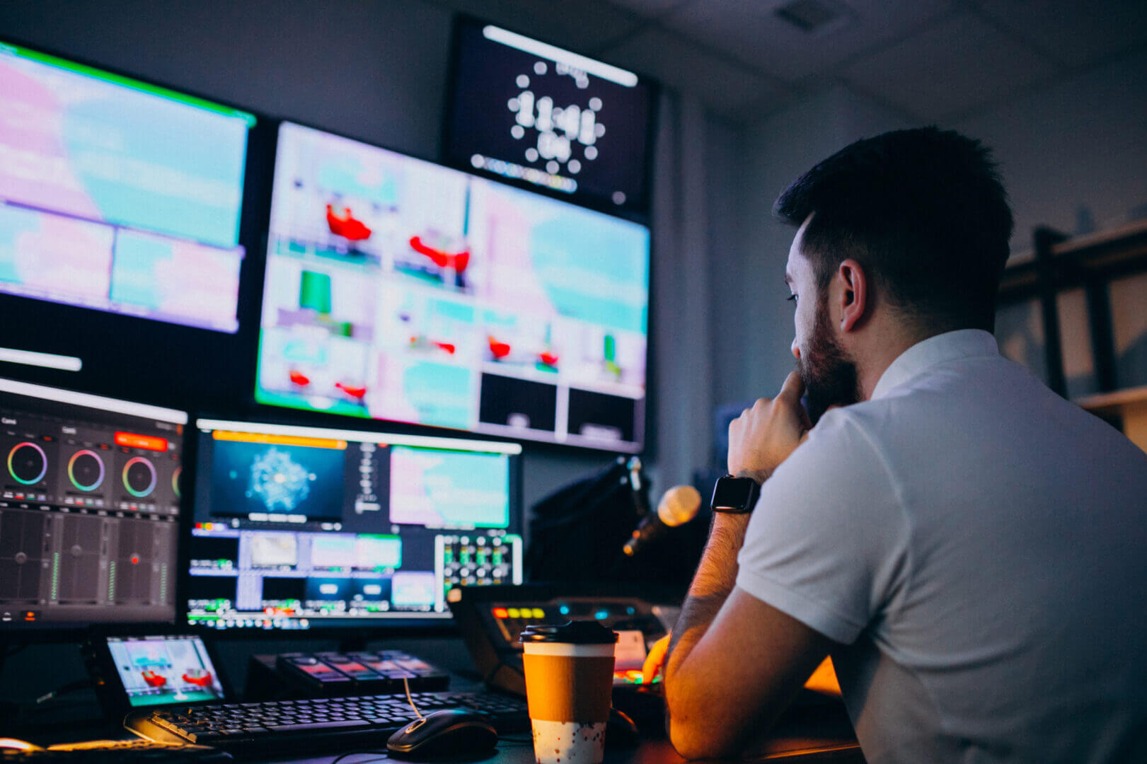 Operador frente a múltiples monitores en una sala de producción audiovisual definida por software y supervisión en tiempo real.