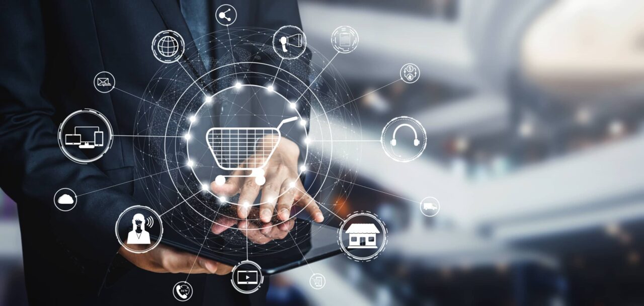 Profesional utiliza una tablet frente a una red digital que conecta e-commerce, tiendas, pagos, logística y atención al cliente en un modelo de comercio unificado.